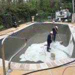 two men cleaning dirty pool