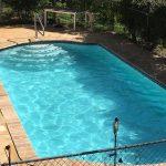 freshly cleaned in-ground pool with clear blue water